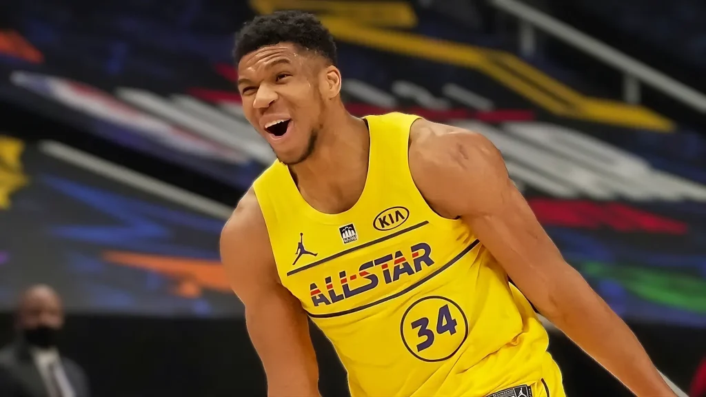 A basketball player in a yellow uniform smiling during the NBA All-Star Game.